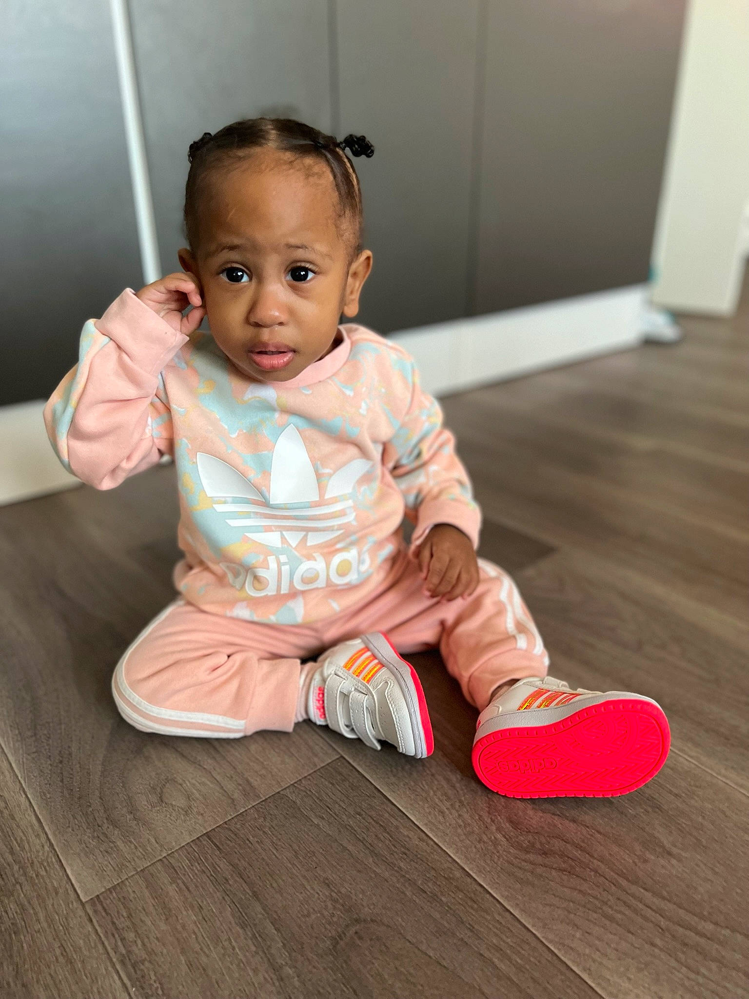 Amelya participe au concours pour gagner de l'argent avec cette photo : baby, baby_toddler_clothing, cheek, child, door, floor, flooring, foot, fun, happy, hardwood, human_leg, nose, person, room, sitting, skin, sleeve, toddler, wood