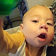 Monty joined the competition — help win amazing prizes! baby, child, selfie, close_up, indoor, curious, open_mouth, face, expression, balloon, fabric, pattern, cozy, person, young_child, portrait, casual, colorful, clothing, curly_hair