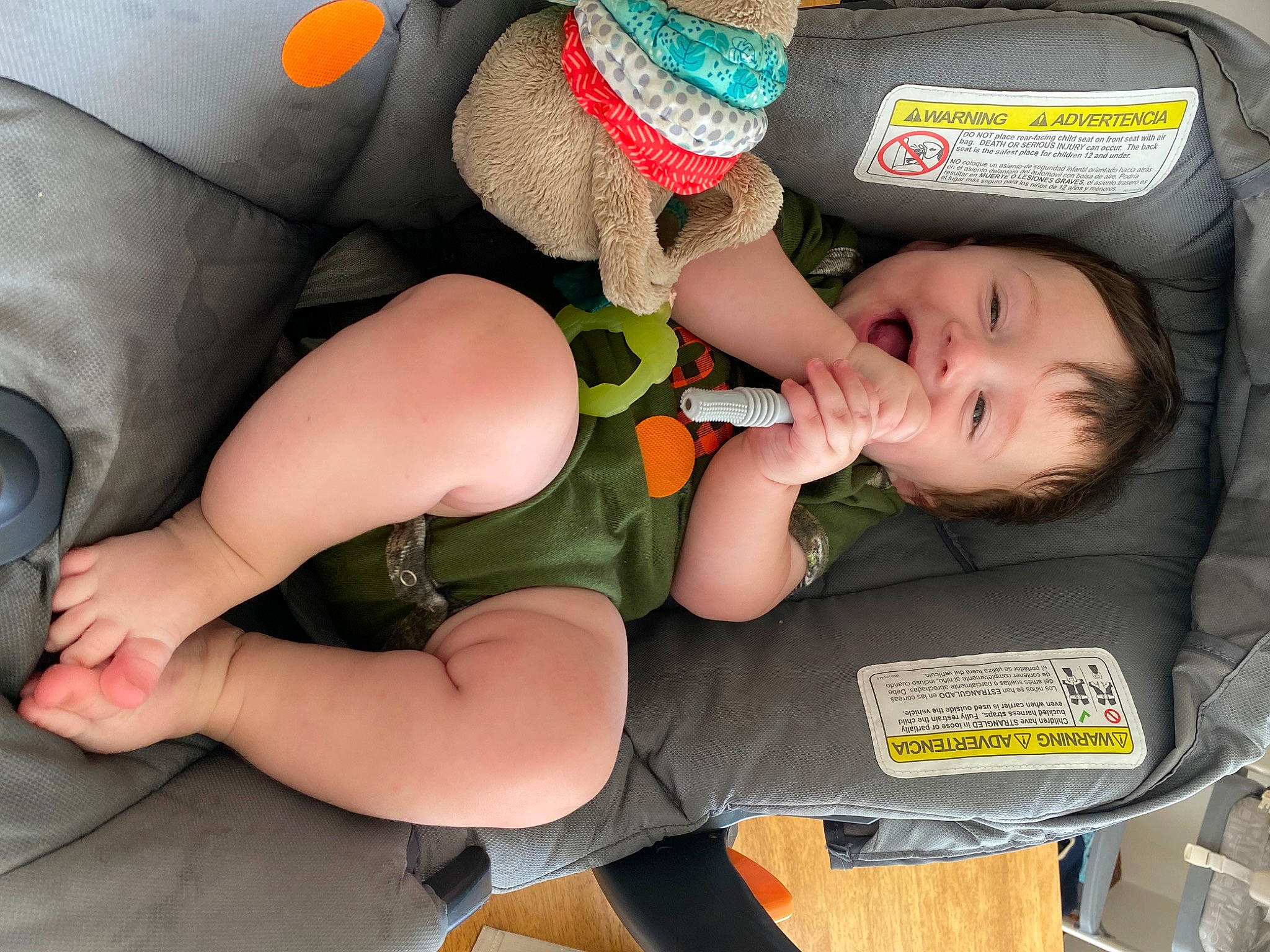 Walker is registered to the contest to win money with this photo: arm, baby, car_seat, chest, elbow, finger, fun, hand, human_body, human_leg, knee, lap, leg, mouth, muscle, person, shoe, snapshot, thigh, trunk