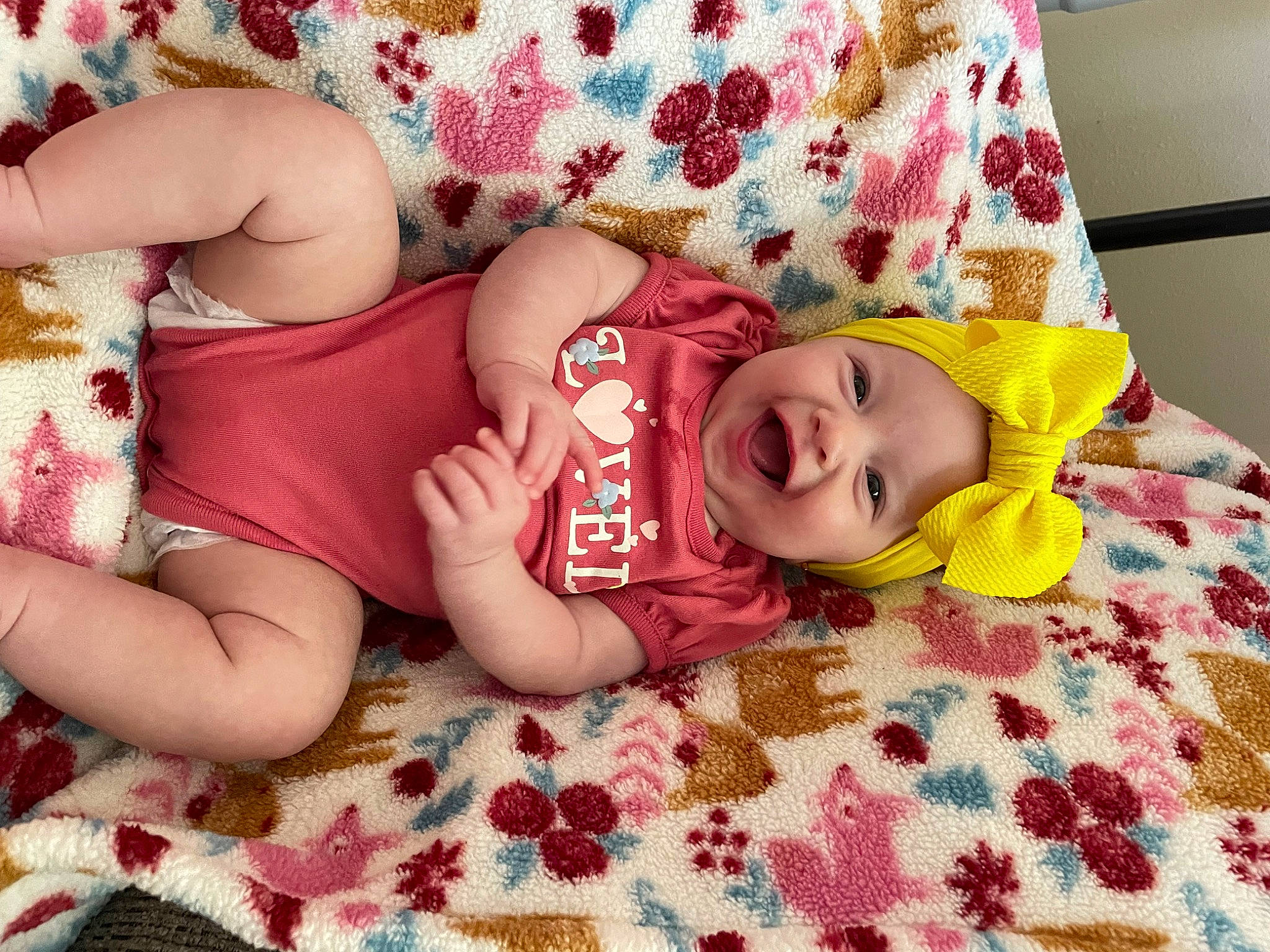 Emersyn is registered to the contest to win money with this photo: baby, baby_toddler_clothing, cheek, child, comfort, eye, happy, head, headgear, headwear, human_body, human_leg, linens, pattern, person, pink, skin, smile, textile, thigh
