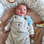 Gabriel participe au concours pour gagner de l'argent avec cette photo : baby, infant, smiling, face, clothing, overalls, mickey_mouse, blue_shirt, blanket, cushion, toy, mirror, leopard_print, lying_down, happy, cute, child, indoors, soft_toys, white_socks