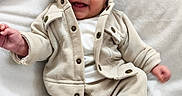 Gabriel a rejoint le concours — aidez-le/la à gagner de superbes lots ! baby, smiling, infant, clothing, jacket, pants, white_blanket, cozy, cute, happy, face, portrait, child, soft_texture, sitting, small_hands, newborn, indoors, warm, casual_wear