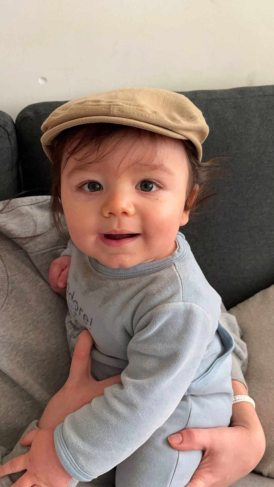 Livio participe au concours pour gagner de l'argent avec cette photo : baby, child, cap, clothing, couch, cute, face, hand, infant, indoors, light_blue, person, portrait, sitting, smile, soft_fabric, toddler, warmth, young_child, headwear