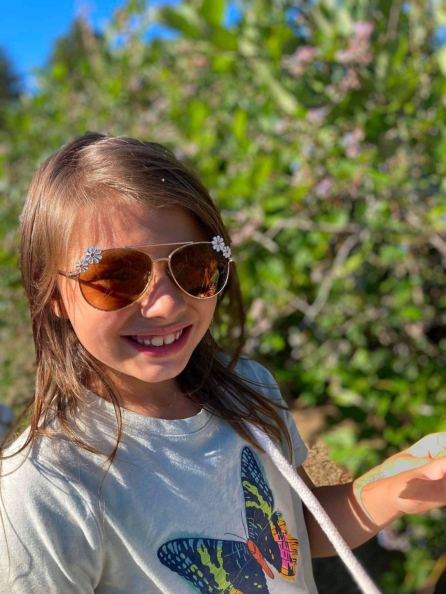 Evalynn is registered to the contest to win money with this photo: botany, community, cool, eyewear, fun, glasses, goggles, grass, guitar_accessory, happy, joy, leaf, leisure, musical_instrument, person, personal_protective_equipment, recreation, smile, sunglasses, t_shirt