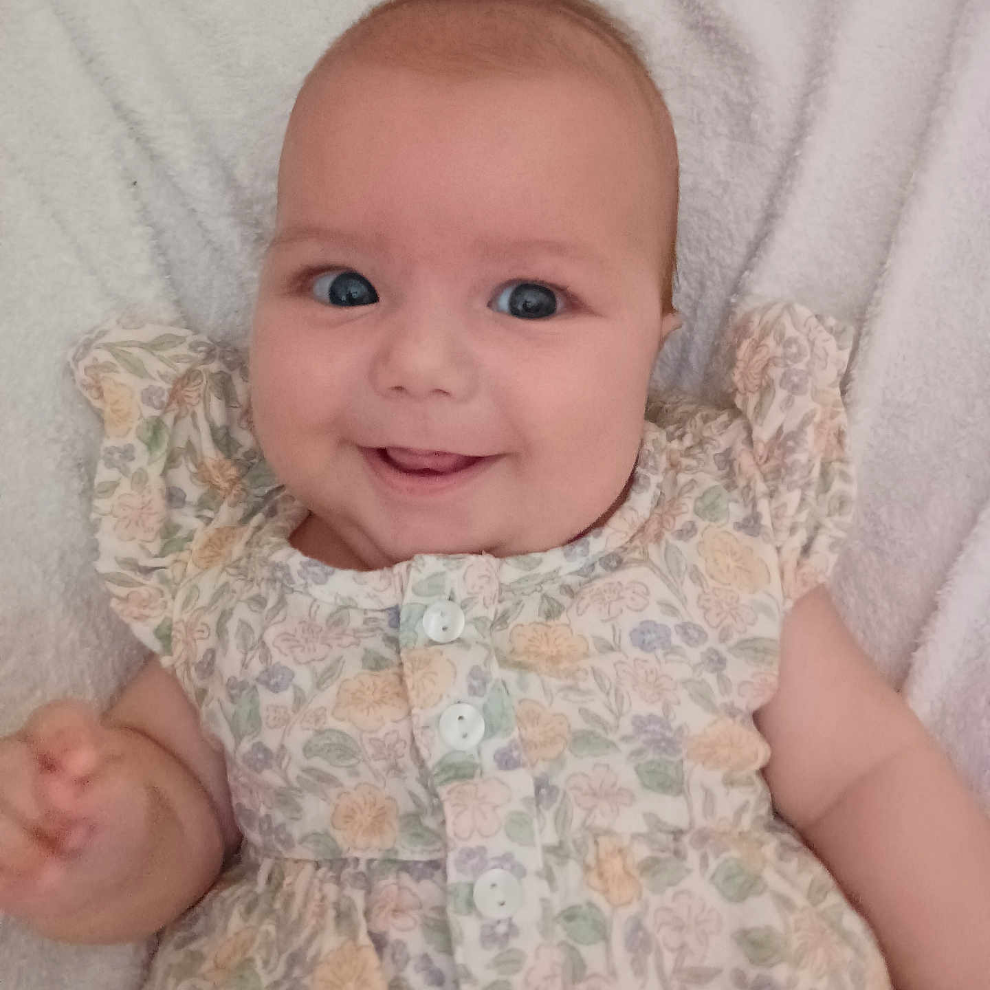 Julia a rejoint le concours — aidez-le/la à gagner de superbes lots ! baby, blanket, buttons, child, cute, dress, eyes, face, floral_pattern, hand, happy, indoors, infant, lying_down, person, portrait, skin, smiling, soft_texture, young