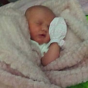 Michelle is registered to the contest to win money with this photo: baby, newborn, sleeping, blanket, mitten, crib, wood, soft, cozy, infant, child, bed, rest, peaceful, closeup, wrapped, face, indoors, person, comfort