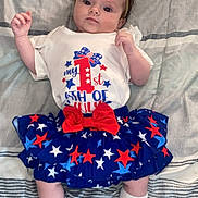 Daisy is registered to the contest to win money with this photo: baby, blanket, blue, bow, child, clothing, cute, headband, infant, lying_down, patriotic, pattern, person, portrait, red, shirt, skirt, socks, stars, white