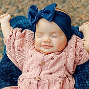 Emory is registered to the contest to win money with this photo: baby, infant, smiling, headband, bow, pink_dress, polka_dot, arms_up, blanket, cozy, outdoor, portrait, peaceful, happy, child, cute, closeup, face, sleepy, soft