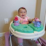 Insaf is registered to the contest to win money with this photo: baby, child, walker, toy, pink, smile, indoor, carpet, clothing, footwear, happy, person, cute, play, infant, face, sitting, home, young, girl