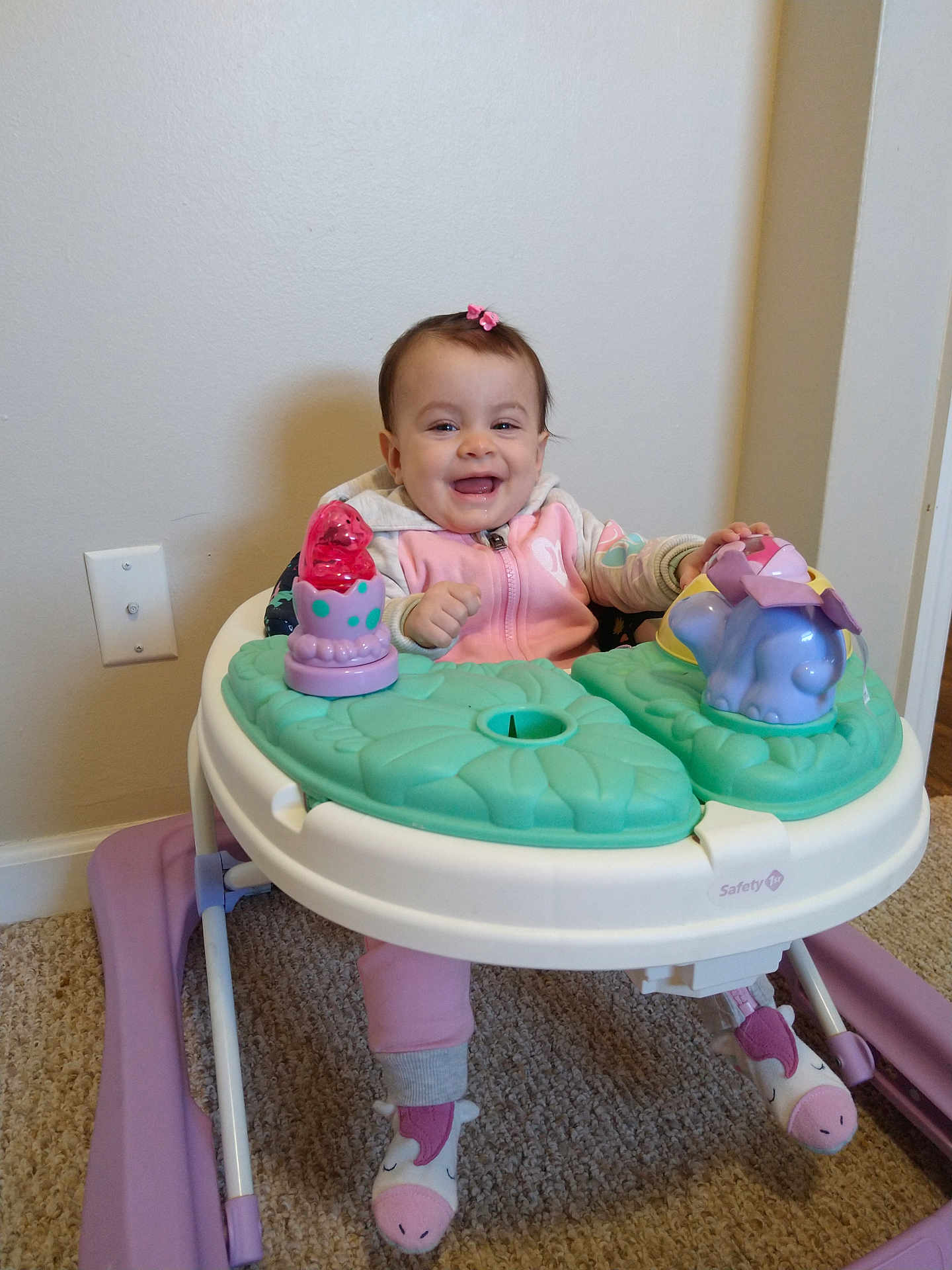 Insaf is registered to the contest to win money with this photo: baby, child, walker, toy, pink, smile, indoor, carpet, clothing, footwear, happy, person, cute, play, infant, face, sitting, home, young, girl