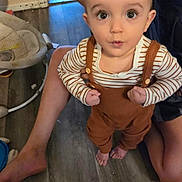 Curtis Loch joined the competition — help win amazing prizes! toddler, child, baby, portrait, standing, wide_eyed, surprised, overalls, striped_shirt, brown_clothing, barefoot, indoor, home, wood_floor, adult, parent, baby_gear, chair, smiling, photography