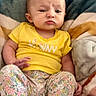 Lyla is registered to the contest to win money with this photo: baby, blanket, casual_clothing, child, cozy, cute, expression, feet, floral_pants, indoors, infant, person, portrait, resting, serious_face, sitting, small_hands, soft_texture, yellow_shirt, young