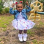 child, girl, swing, playground, grass, dress, denim_jacket, red_bows, smile, outdoor, fence, toy, shoes, socks, happy, nature, daylight, fun, young, person