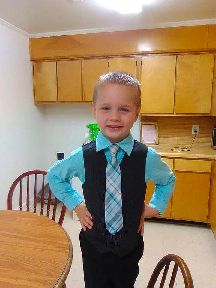 Shawn is registered to the contest to win money with this photo: bow_tie, child, formal_wear, person, room, school_uniform, standing, suit, tie, toddler, tuxedo, uniform