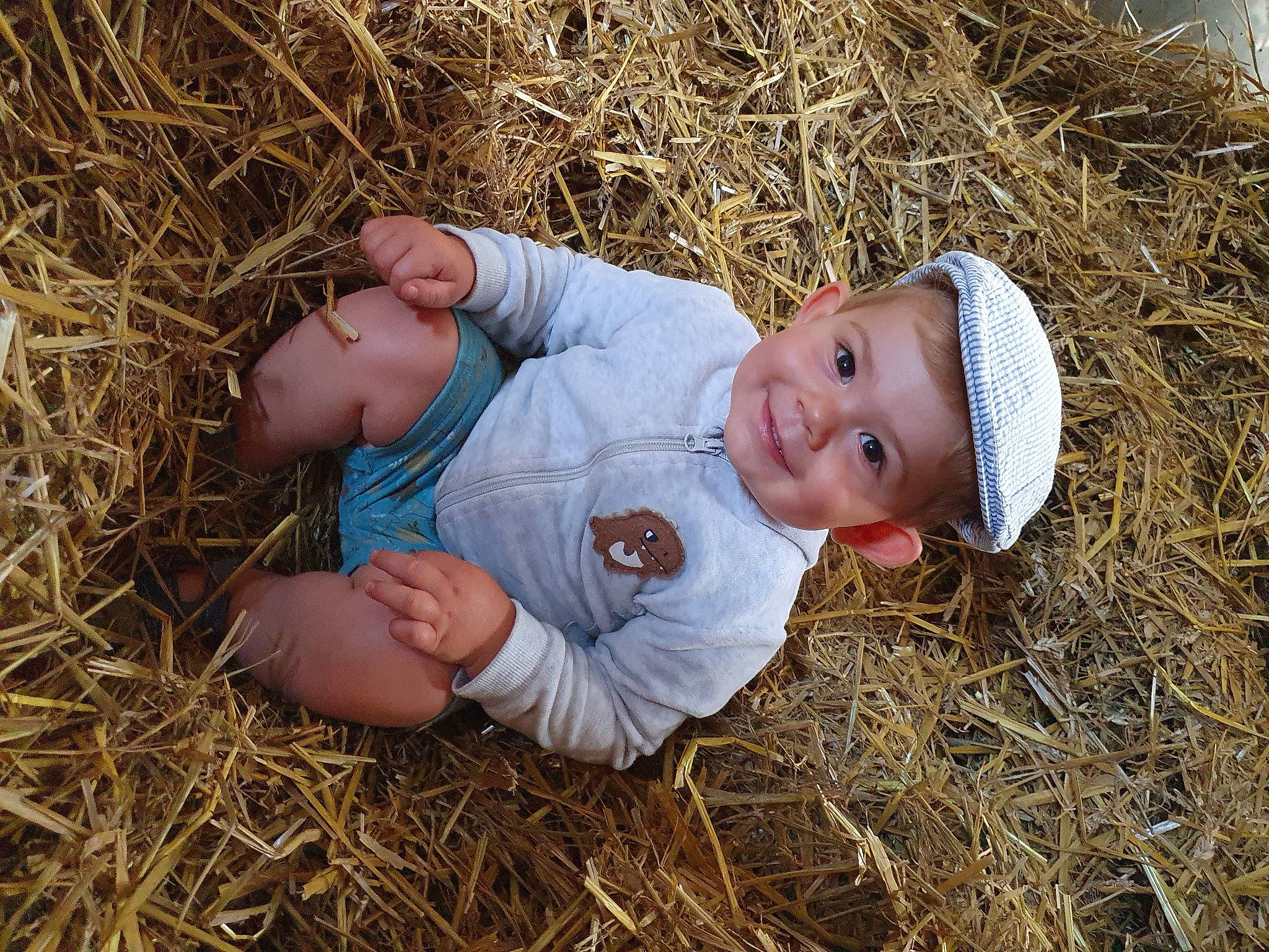 Mathys a rejoint le concours — aidez-le/la à gagner de superbes lots ! agriculture, baby, baby_toddler_clothing, event, face, field, grass, grass_family, grassland, happy, hat, hay, head, headwear, joy, people_in_nature, person, plant, prairie, smile