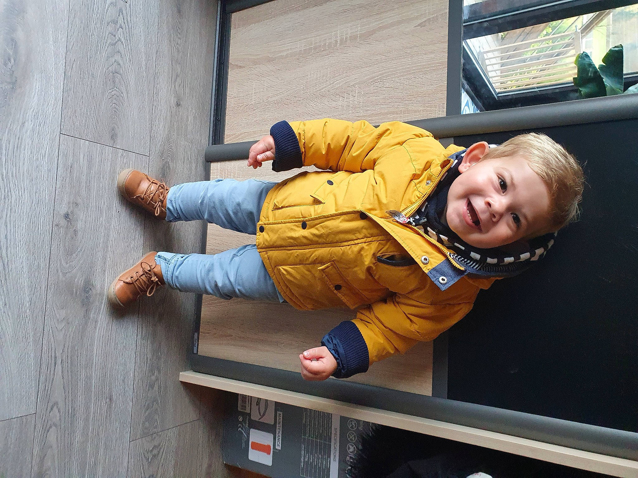 Mathys a rejoint le concours — aidez-le/la à gagner de superbes lots ! baby_toddler_clothing, child, comfort, foot, human_leg, jacket, joy, outdoor_shoe, person, sitting, sleeve, smile, street_fashion, thigh, toddler, travel, wood