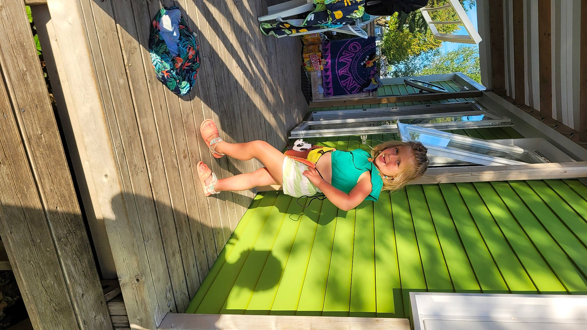 Taïna participe au concours pour gagner de l'argent avec cette photo : child, flooring, fun, games, grass, green, hardwood, human_leg, leisure, line, person, play, recreation, room, sandal, shorts, thigh, toddler, tree, vacation