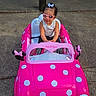 child, toddler, toy_car, pink, minnie_mouse, sunglasses, outdoor, concrete, bench, play, cute, polka_dots, bow, hair_bow, summer, fun, smile, seat, vehicle, daytime