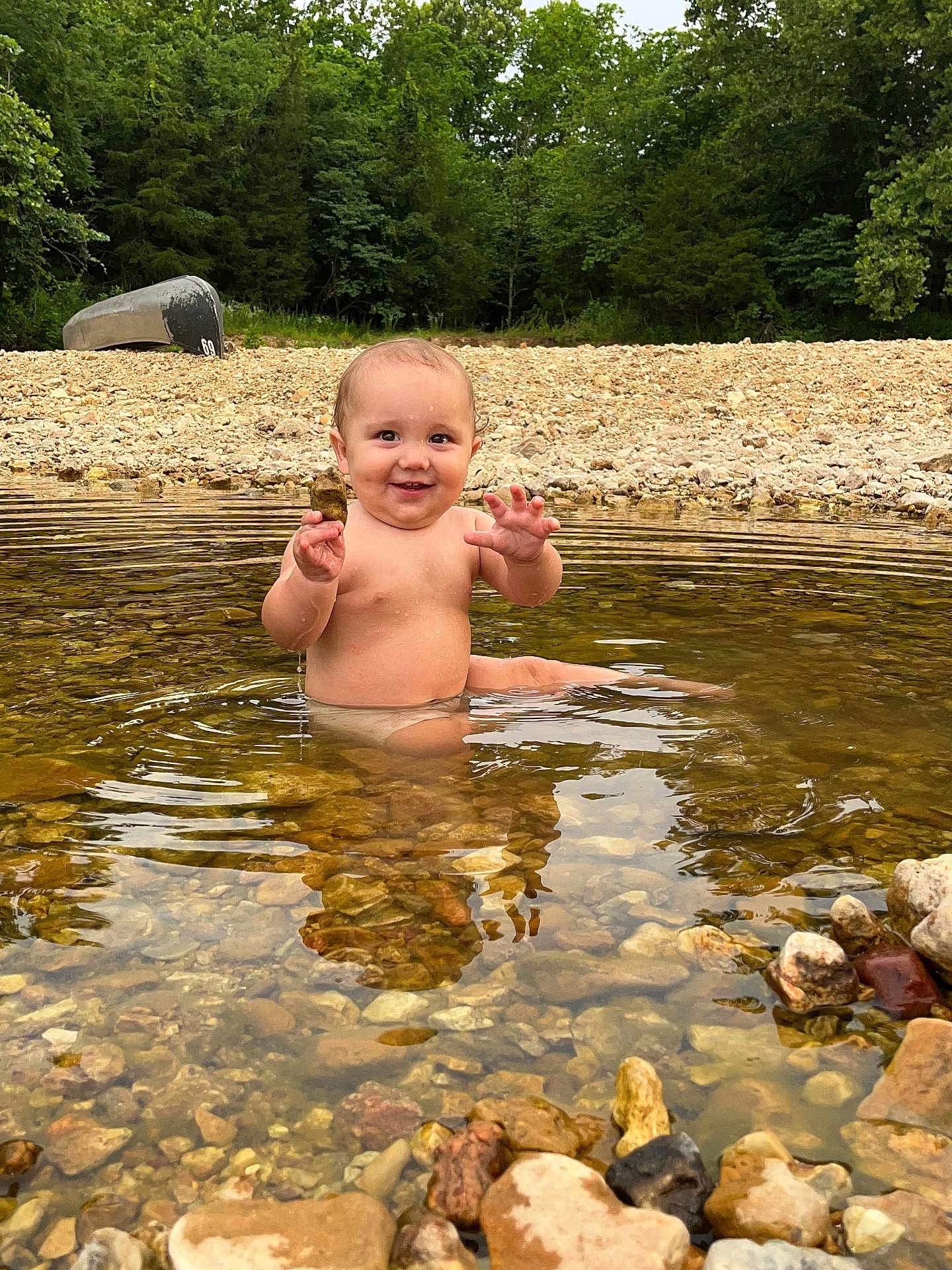 Navy joined the competition — help win amazing prizes! baby, child, water, river, rocks, nature, outdoor, forest, canoe, smiling, happy, bare_chested, sitting, shallow_water, reflection, summer, playful, person, daylight, scenic