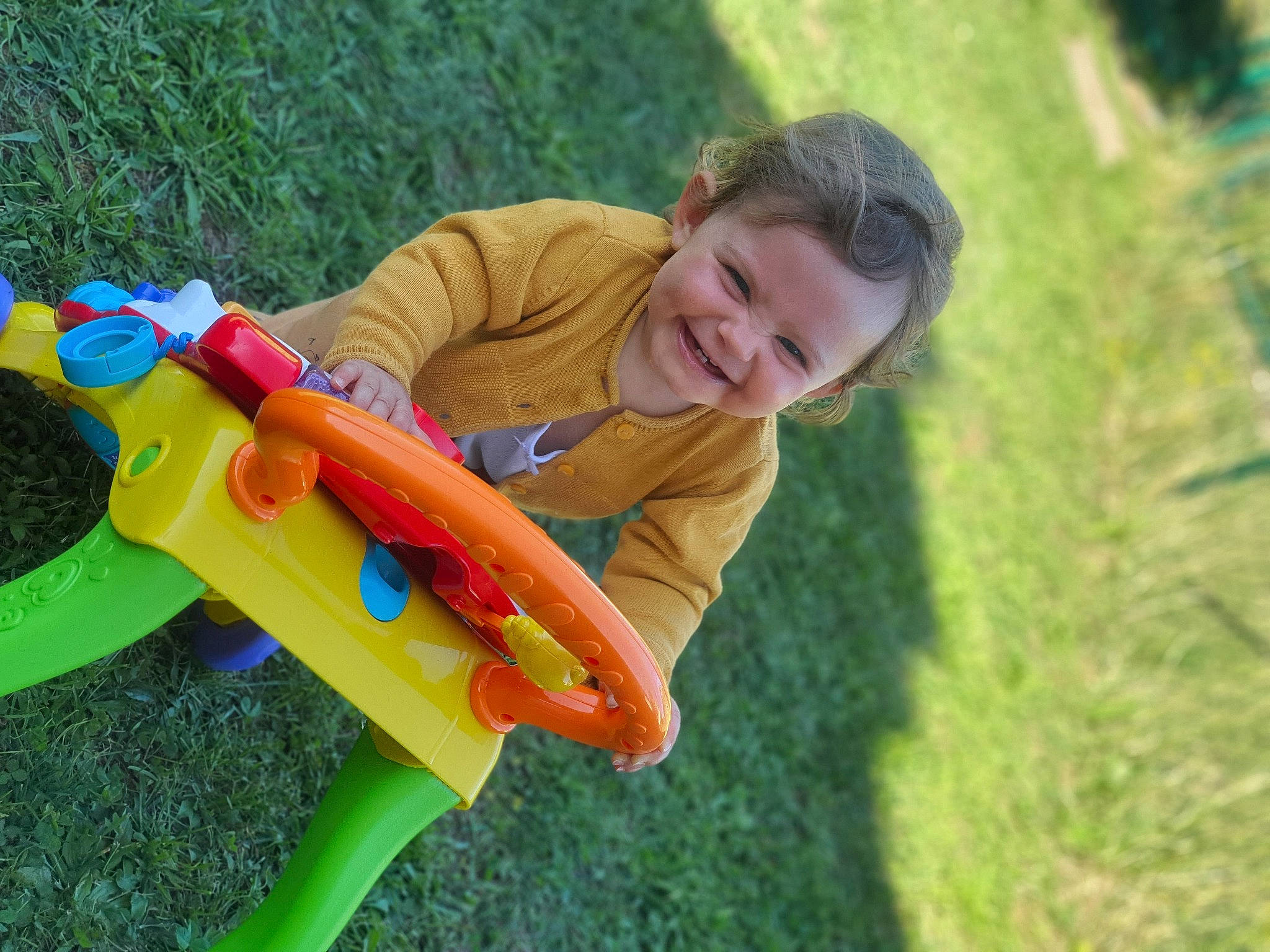 Noëlya participe au concours pour gagner de l'argent avec cette photo : baby_toddler_clothing, child, city, fun, grass, grass_family, grassland, happy, joy, lawn, leisure, outdoor_furniture, outdoor_play_equipment, people_in_nature, person, plant, recreation, riding_toy, smile, toddler