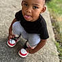 Joliyah joined the competition — help win amazing prizes! toddler, child, playful, squatting, sidewalk, black_tshirt, gray_pants, sneakers, butterfly_clips, hair, curly_hair, outdoor, grass, earrings, face, tongue_out, cute, portrait, person, expression