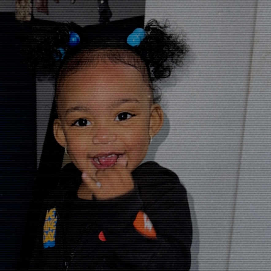 Joliyah joined the competition — help win amazing prizes! black_clothing, child, curly_hair, cute, expression, face, finger, hair, hair_ties, happy, head, indoor, indoors, person, portrait, skin, smiling, standing, toddler, young_child