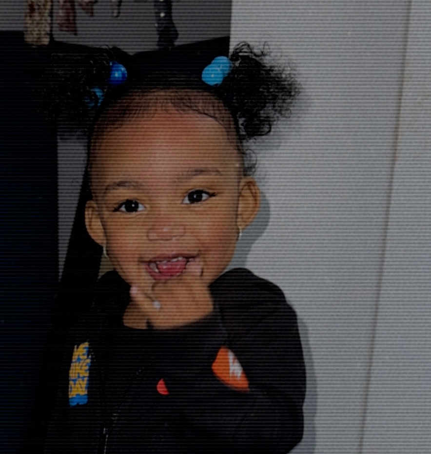 Joliyah joined the competition — help win amazing prizes! toddler, child, smiling, indoor, hair_ties, curly_hair, black_clothing, face, happy, person, portrait, cute, young_child, expression, standing, skin, head, hair, finger, indoors
