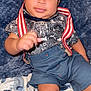 Cameron joined the competition — help win amazing prizes! baby, child, infant, clothing, shirt, shorts, suspenders, blanket, blue, patterned, hand, smiling, face, eyes, hair, cute, lying_down, comfort, soft_texture, animal_print