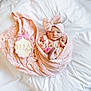 Ella is registered to the contest to win money with this photo: baby, bow, child, cozy, cute, headband, infant, knitwear, lying_down, name_tag, newborn, person, pink_blanket, portrait, sleepwear, soft_texture, white_bed, winking, wooden_plaque, wrapped