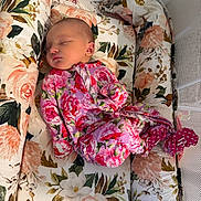 Ella is registered to the contest to win money with this photo: baby, bed, bedding, child, comfort, crib, cute, fabric, floral, indoors, infant, newborn, onesie, pattern, peaceful, person, pink, resting, sleeping, soft_lighting