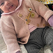Lina a rejoint le concours — aidez-le/la à gagner de superbes lots ! baby, smile, knitwear, pink, gray_pants, blanket, plush_toy, cozy, cute, infant, clothing, fabric, indoors, portrait, child, soft, warm, happy, face, sitting