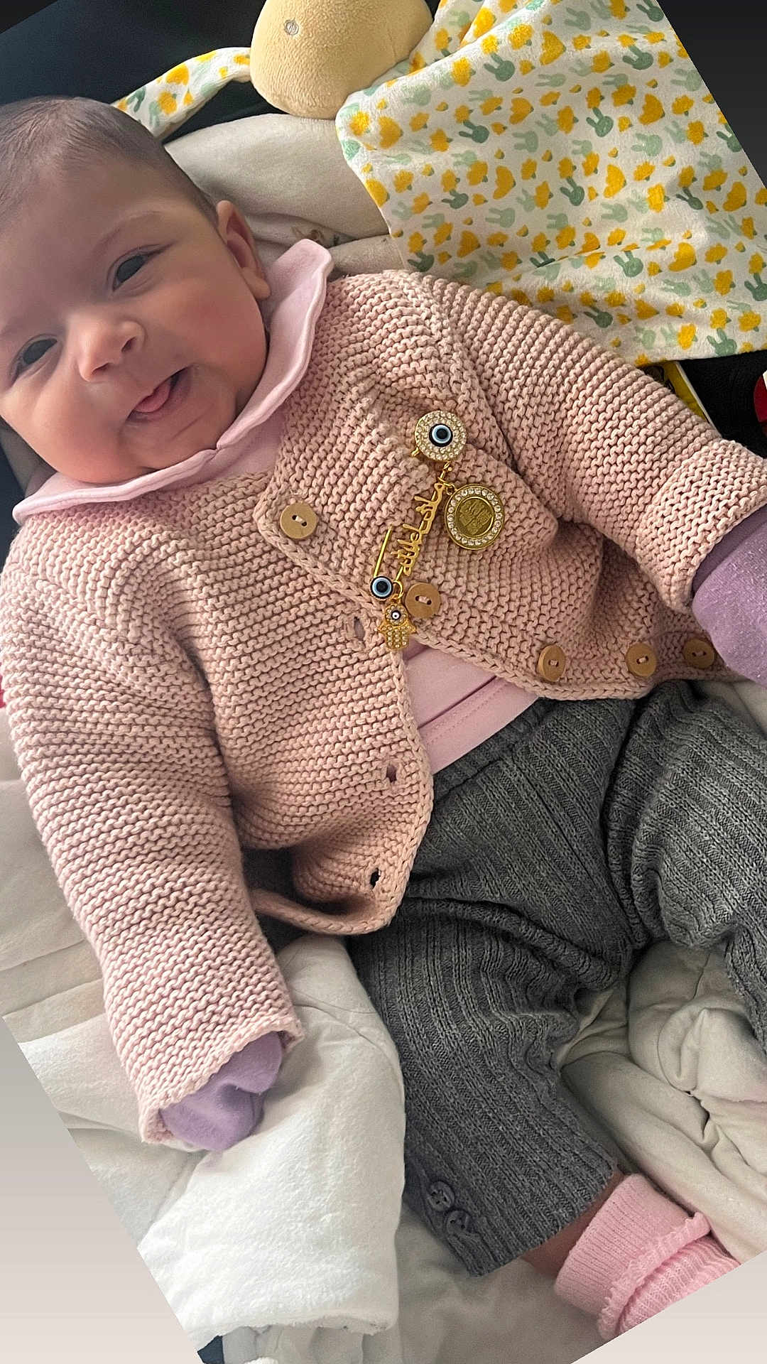 Lina a rejoint le concours — aidez-le/la à gagner de superbes lots ! baby, smile, knitwear, pink, gray_pants, blanket, plush_toy, cozy, cute, infant, clothing, fabric, indoors, portrait, child, soft, warm, happy, face, sitting