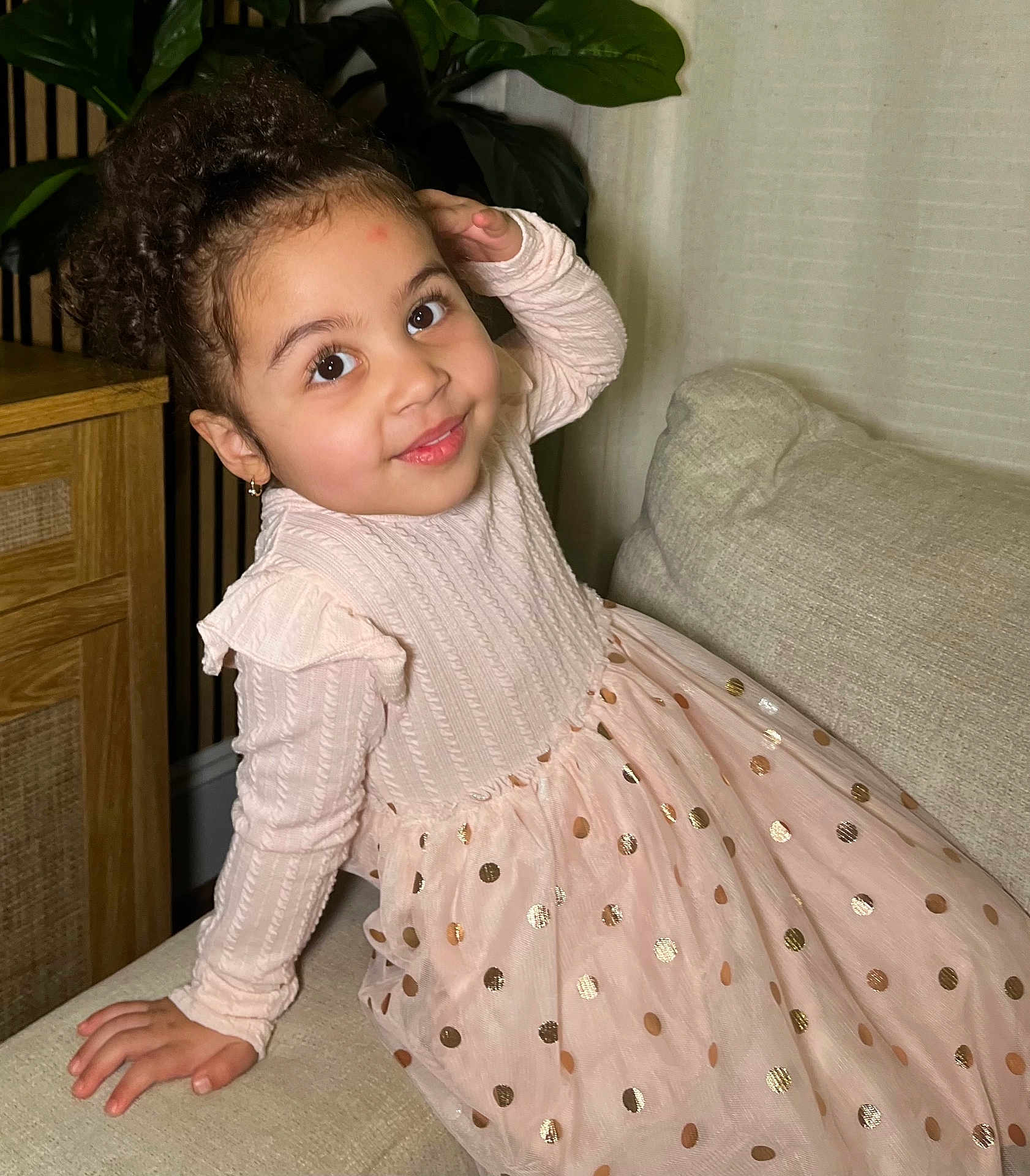 Luzmery joined the competition — help win amazing prizes! child, girl, curly_hair, pink_dress, polka_dots, smiling, couch, indoor, plant, wooden_cabinet, home_decor, portrait, happy, cute, sitting, long_sleeves, earrings, cozy, fashion, young