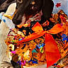 dog, dachshund, puppy, black_and_tan, pet, animal, portrait, halloween, gift_wrapping, orange_bow, ribbon, costume, sparkles, blanket, couch, indoor, cozy, festive, cute, close_up