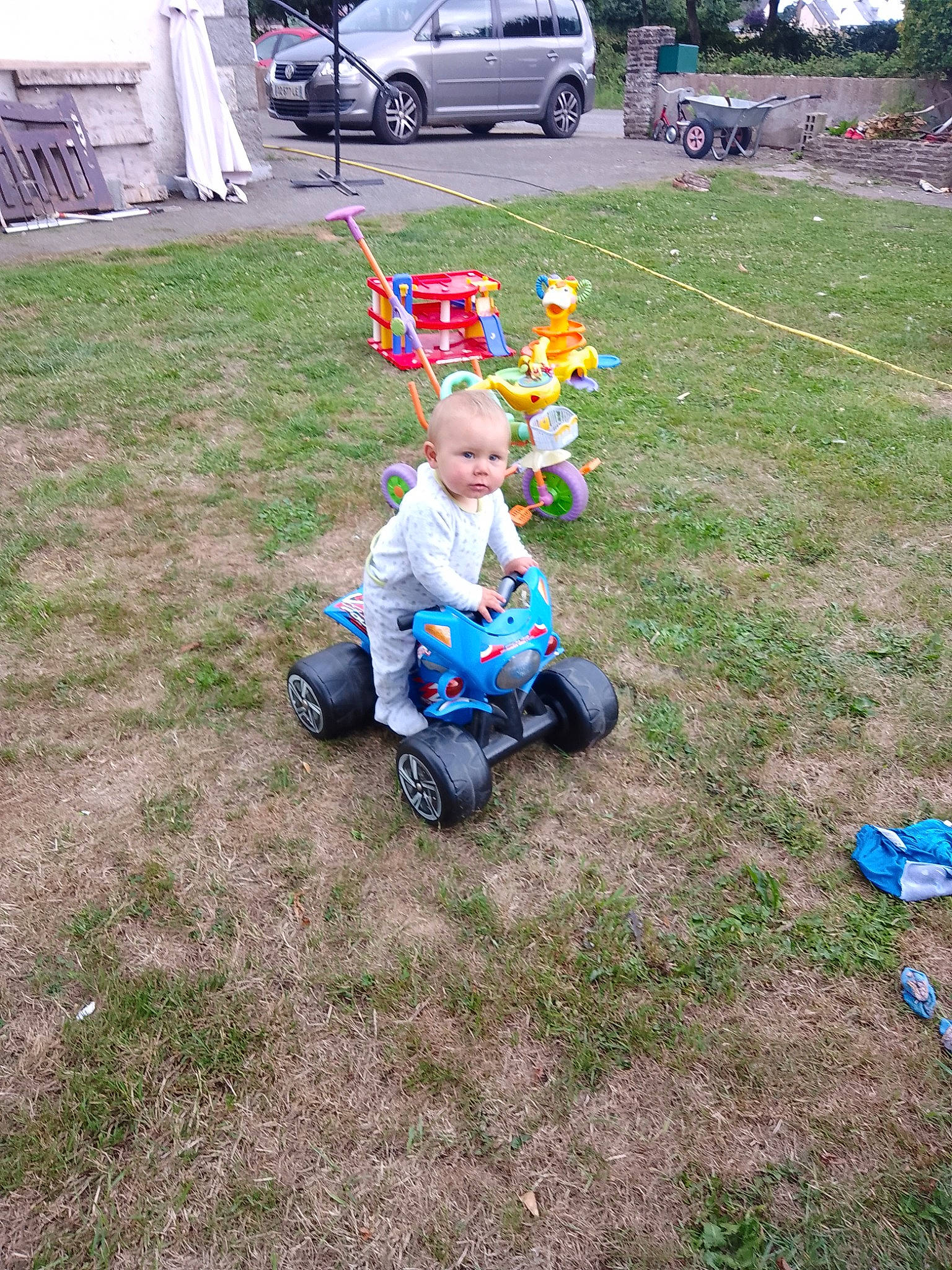 Gabin a rejoint le concours — aidez-le/la à gagner de superbes lots ! asphalt, automotive_tire, automotive_wheel_system, baby, car, fun, grass, lawn, person, plant, recreation, smile, soil, tire, toddler, toy, tree, truck, van, vehicle