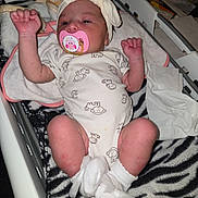 Aiyana is registered to the contest to win money with this photo: baby, newborn, pacifier, headband, onesie, monkey_pattern, blanket, zebra_print, laundry_basket, infant, clothing, sleeping, cute, small, white_socks, raised_arms, indoors, soft_lighting, resting, person
