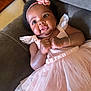 Reina is registered to the contest to win money with this photo: baby, child, girl, pink_dress, headband, flower, couch, smile, cute, infant, portrait, hand, fingers, happy, indoors, tulle, bracelet, skin, face, young