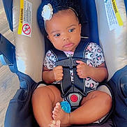 Reina is registered to the contest to win money with this photo: baby, car_seat, child, infant, headband, flower, safety_harness, foot, hand, clothing, pattern, indoor, floor, seat, cute, person, young_child, portrait, secure, resting