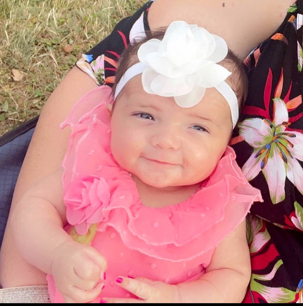 Marianna is registered to the contest to win money with this photo: baby, baby_products, baby_toddler_clothing, face, finger, flower, grass, happy, headband, headgear, headpiece, headwear, joy, magenta, person, petal, photograph, pink, plant, skin