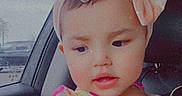 Angelina Ruby is registered to the contest to win money with this photo: toddler, child, car, headband, bow, pink, dress, colorful, portrait, indoors, window, seat, cute, young_child, baby, smiling, person, fashion, accessory, happy