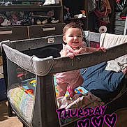 Angelina Ruby joined the competition — help win amazing prizes! baby, playpen, smiling, child, indoor, television, furniture, clothing, toy, floor, wooden_floor, cabinet, blanket, bottle, heart, text_overlay, person, room, happy, standing