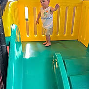 Carinlefty is registered to the contest to win money with this photo: toddler, child, playground, slide, yellow, teal, plastic, play_area, indoor, childrens_playground, barefoot, shorts, tank_top, cute, heart_graphics, fun, adventure, young_child, smiling, curly_hair