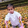 Maëlys a rejoint le concours — aidez-le/la à gagner de superbes lots ! child, toddler, autumn, leaves, outdoor, play, toy, stroller, pink, hair, pigtails, white_sweater, curious, nature, grass, steps, daylight, person, clothing, fall