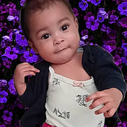 Kessy a rejoint le concours — aidez-le/la à gagner de superbes lots ! toddler, child, red_bow, purple_flowers, background, curious, smile, cute, clothing, pants, cardigan, portrait, nature, flora, outdoor, person, baby, face, young_child, happy