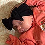Melody is registered to the contest to win money with this photo: baby, sleeping, headband, bow, black, coral_clothing, infant, patterned_blanket, cute, peaceful, soft_lighting, closeup, portrait, newborn, resting, hand, skin, indoors, cozy, fabric
