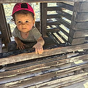 Ava participe au concours pour gagner de l'argent avec cette photo : toddler, child, beach, sand, wood, wooden_structure, hat, cap, polka_dot, sunlight, shadow, outdoor, curious, face, hand, clothing, play, summer, vacation, nature