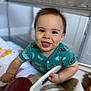 Santiago is registered to the contest to win money with this photo: baby, child, playpen, onesie, teal_clothing, fish_pattern, crawling, tongue_out, basket, toy, football, happy, indoor, face, smiling, hand, fabric, cute, infant, playtime