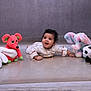 Bruhatreddy is registered to the contest to win money with this photo: baby, child, stuffed_animals, toy_elephant, toy_panda, toy_mouse, floor, indoor, curly_hair, white_clothing, smiling, playful, cute, infant, portrait, soft_toys, happy, bright, expression, crawling