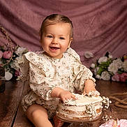 Alizée a rejoint le concours — aidez-le/la à gagner de superbes lots ! baby, cake, cake_smash, cake_stand, child, decor, dress, feet, floral, flowers, frosting, hands, laughing, pink_backdrop, portrait, roses, smile, studio, toddler, wooden_floor