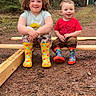child, children, outdoor, forest, boots, rain_boots, wood, smile, happy, nature, grass, trees, play, sitting, casual_clothes, toddler, cute, daylight, two_people, ground